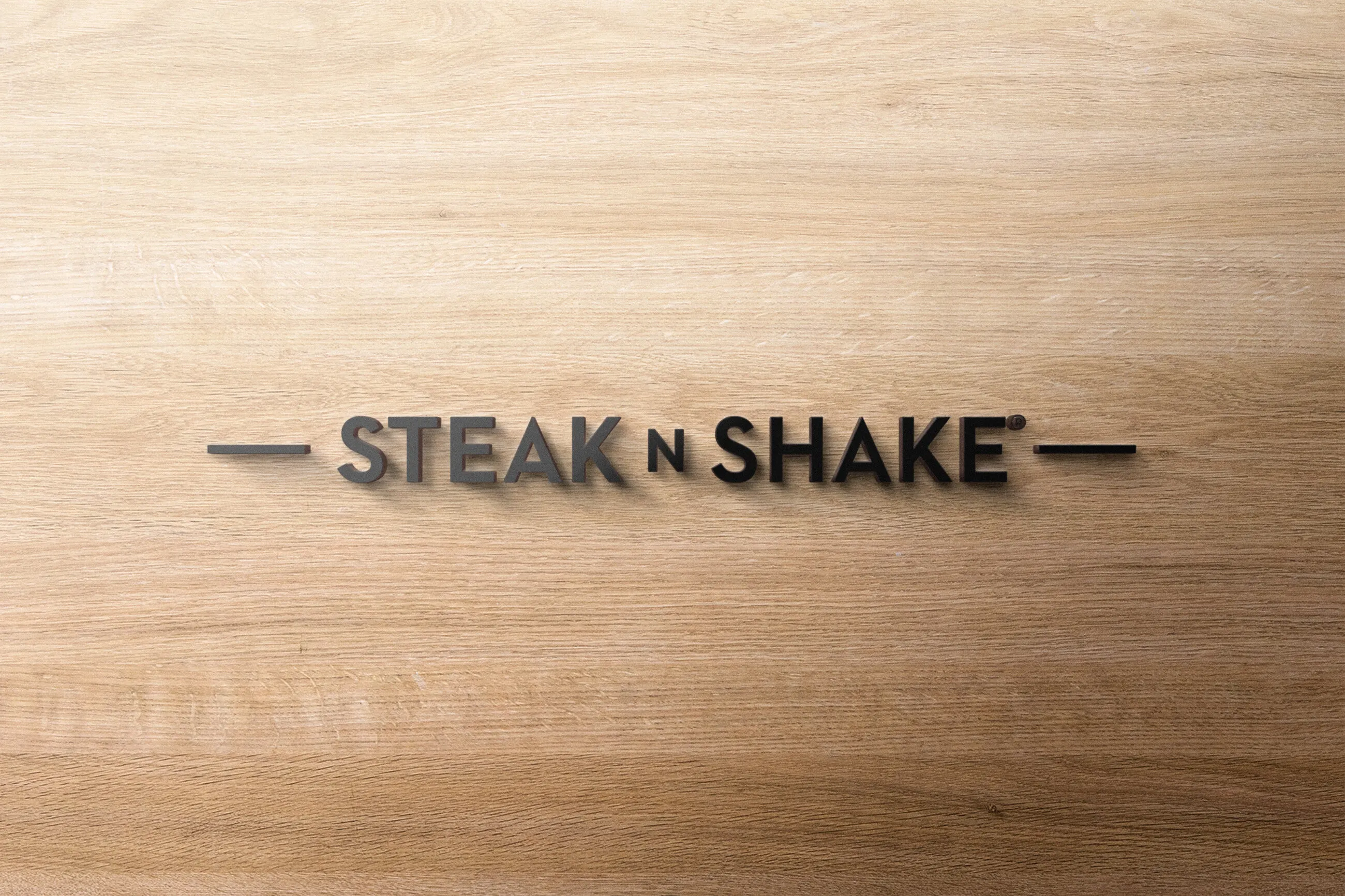 Logo Steak’n Shake en relief métallique sur un mur en bois