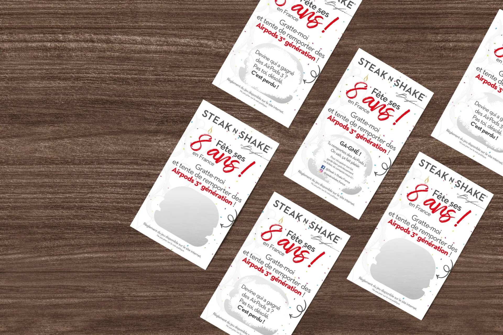 Cartes « 8 ans » Steak’n Shake sur une table en bois