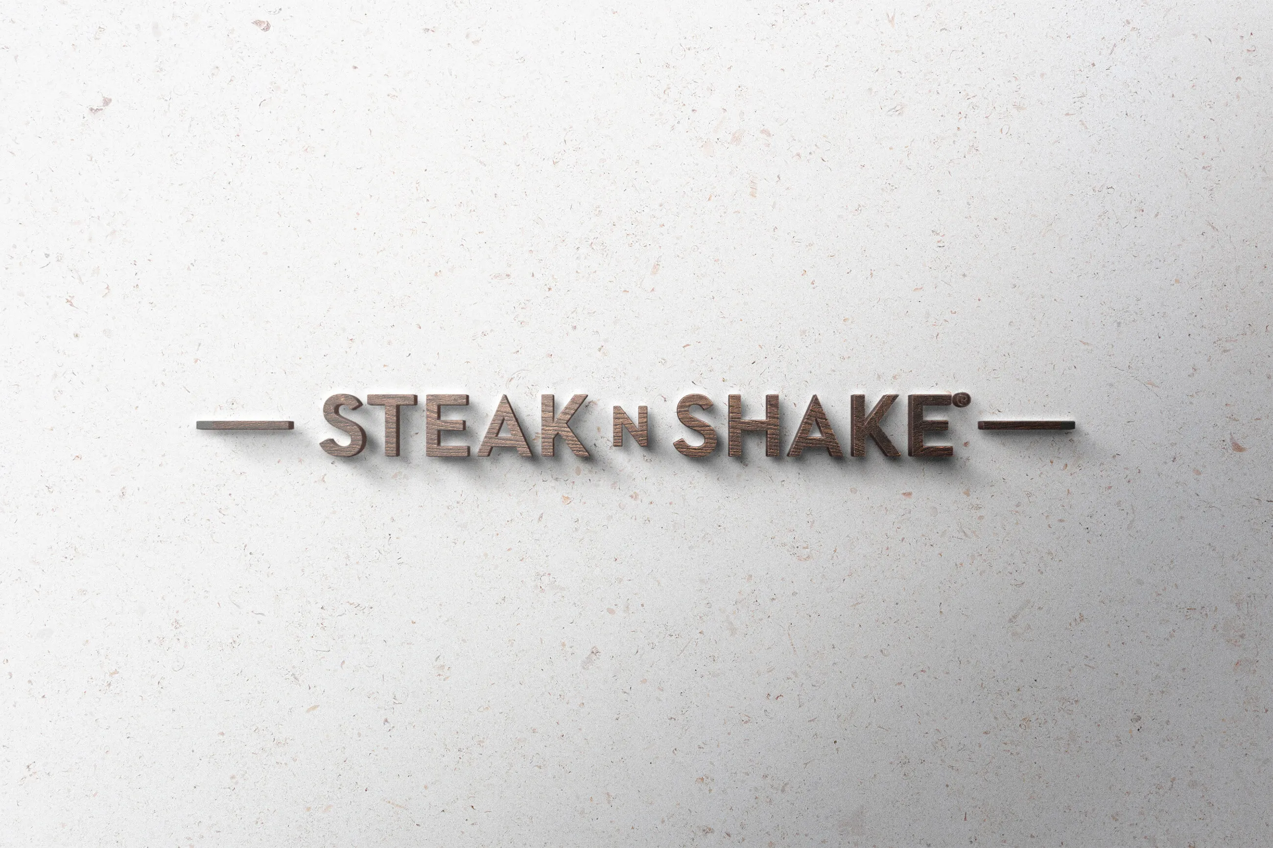 Logo Steak’n Shake en relief métallique sur un mur blanc